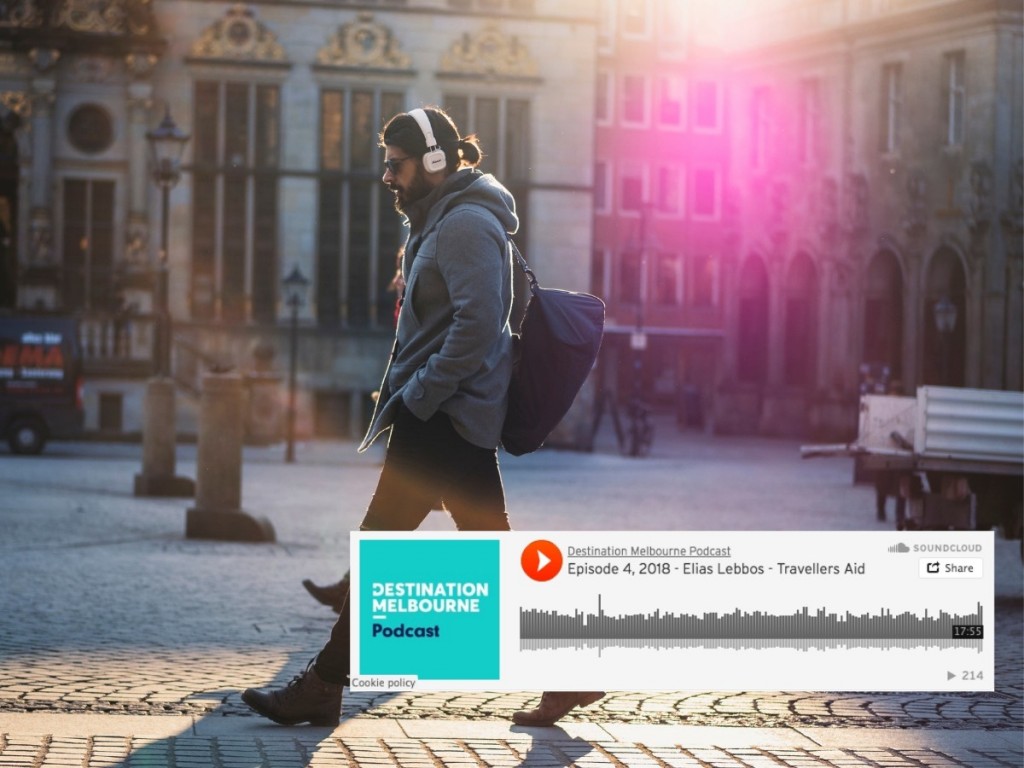 Photo of man walking in city with headphone on