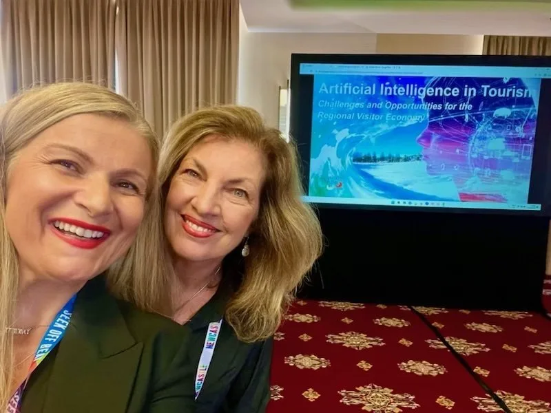 Liz Ward and Despina Karatzias at tourism conference presenting on artificial intelligence.