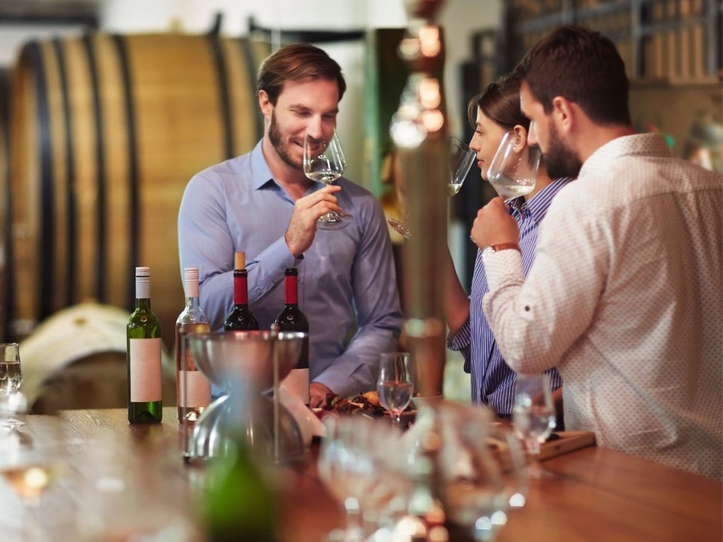 Three customers taste wine at a winery