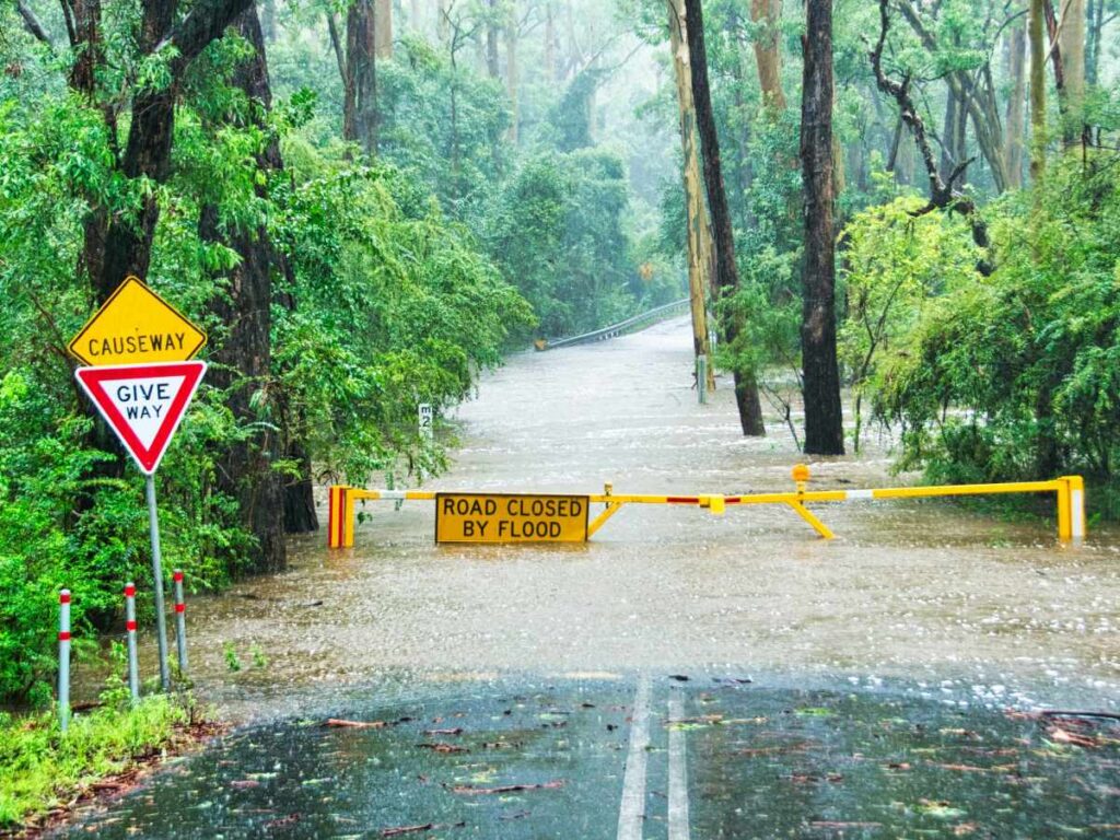 Flooded road with barrier stopping cars.