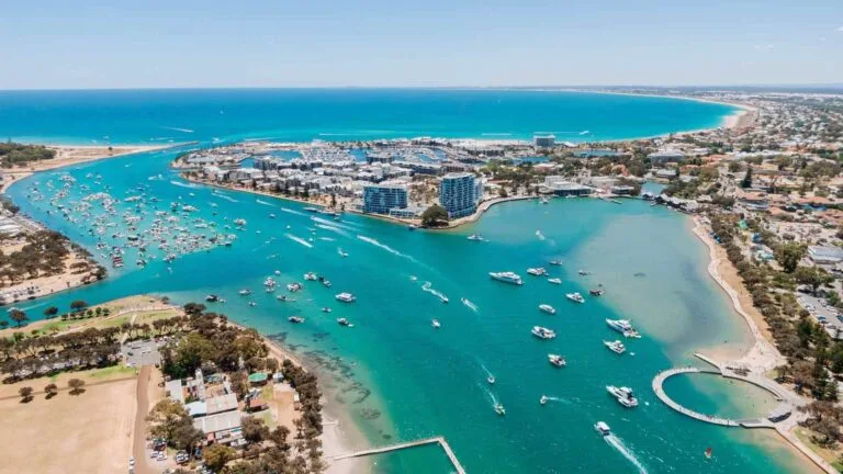 Aerial view of Mandurah estuary with boats, beaches, and coastal development, Western Australia.