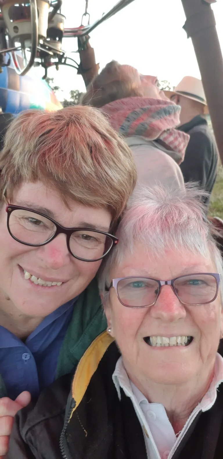 Steph and Jan smiling at camera inside hot air balloon basket.