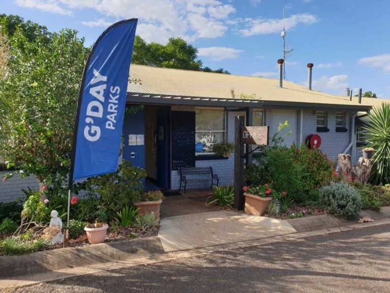 G'day Parks visitor centre with blue flag banner and native gardens.