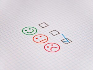 online reputation increasing customer reviews in 2022 - photo of paper with happy, neutral and sad faces next to tick boxes.jpg